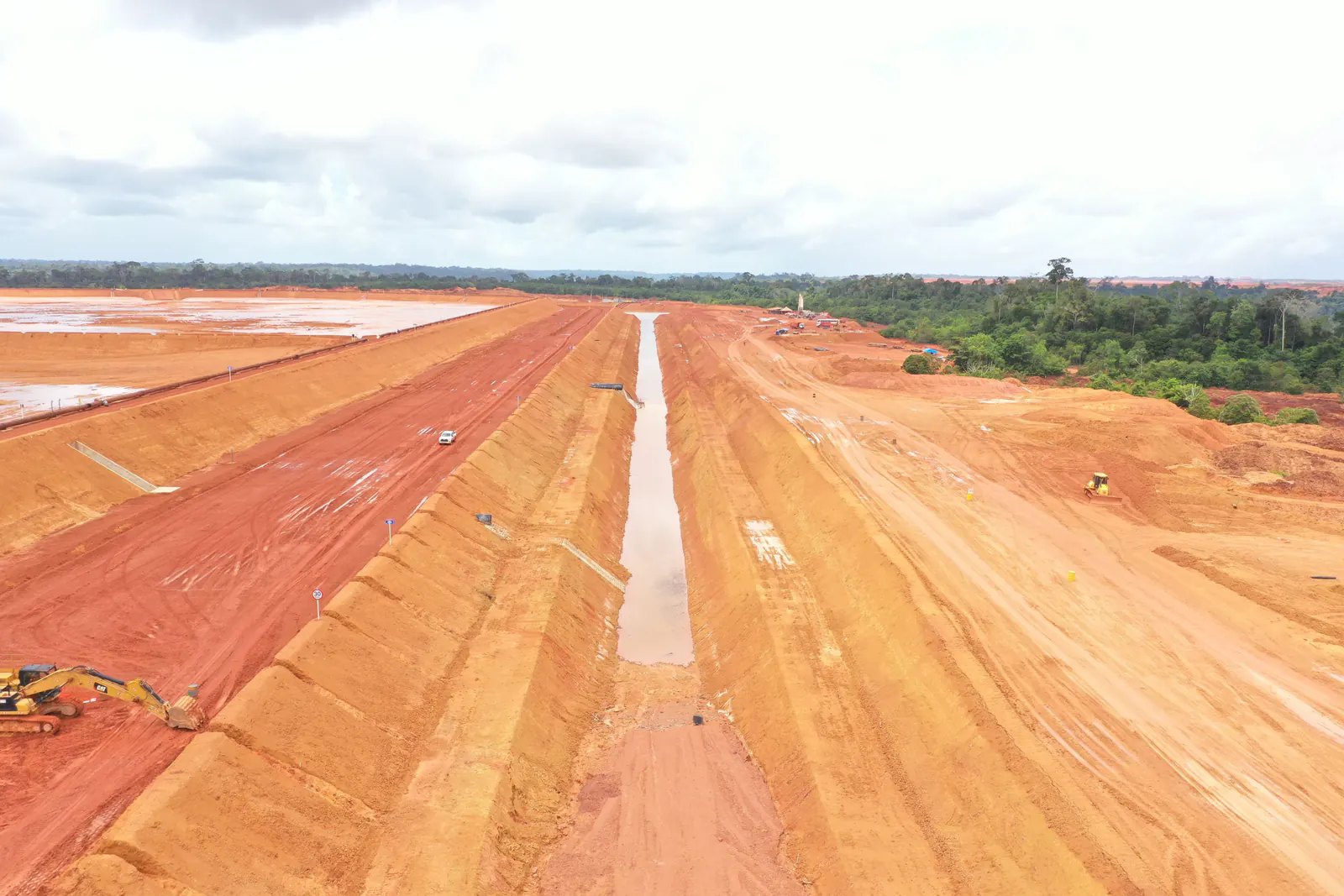Canal de drenagem retilíneo ao longo da barragem, visto do alto
