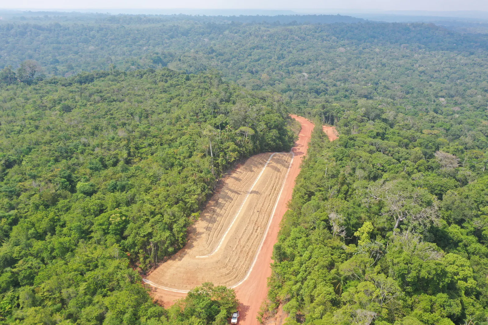 Vista aérea do talude conformado na encosta, com a floresta ao redor