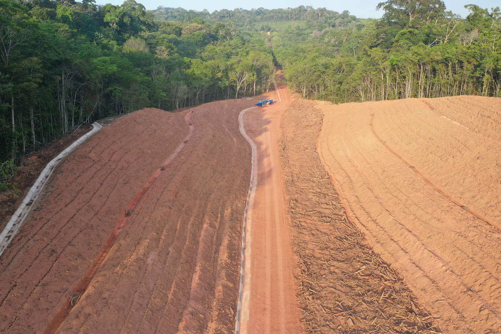 Vista frontal, do alto, do talude retaludado com a floresta dos dois lados