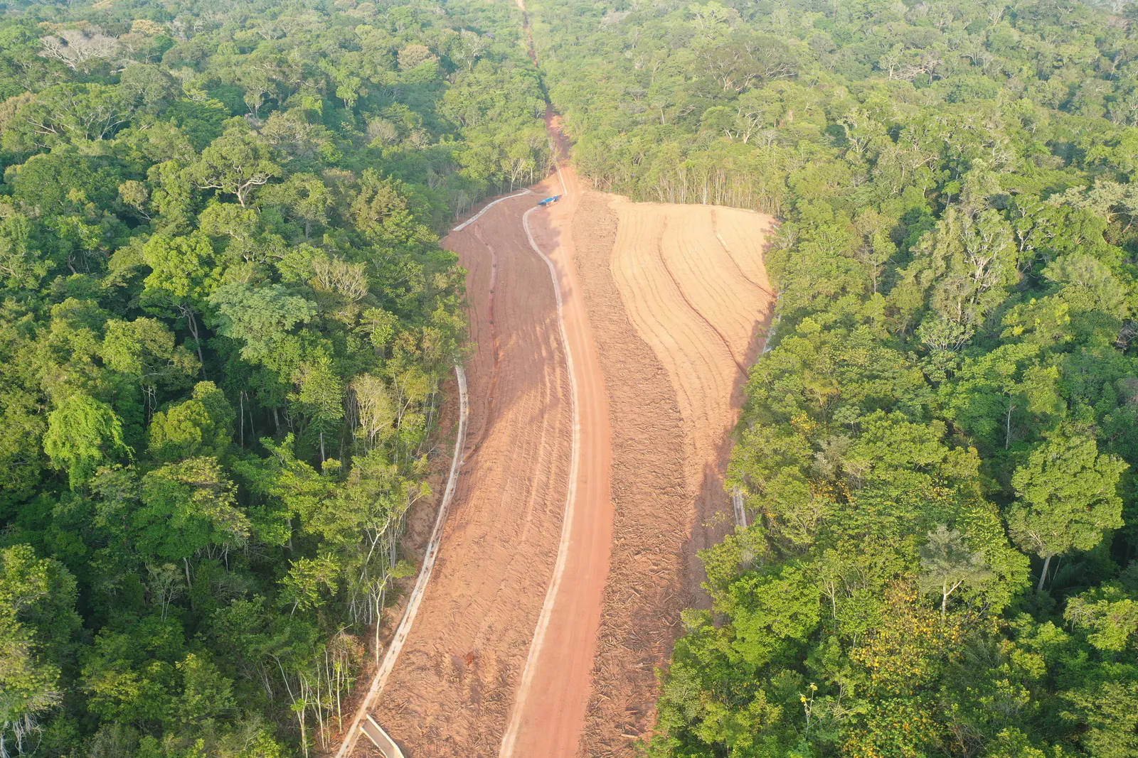 Vista aérea de faixa estreita de talude conformado entre a mata